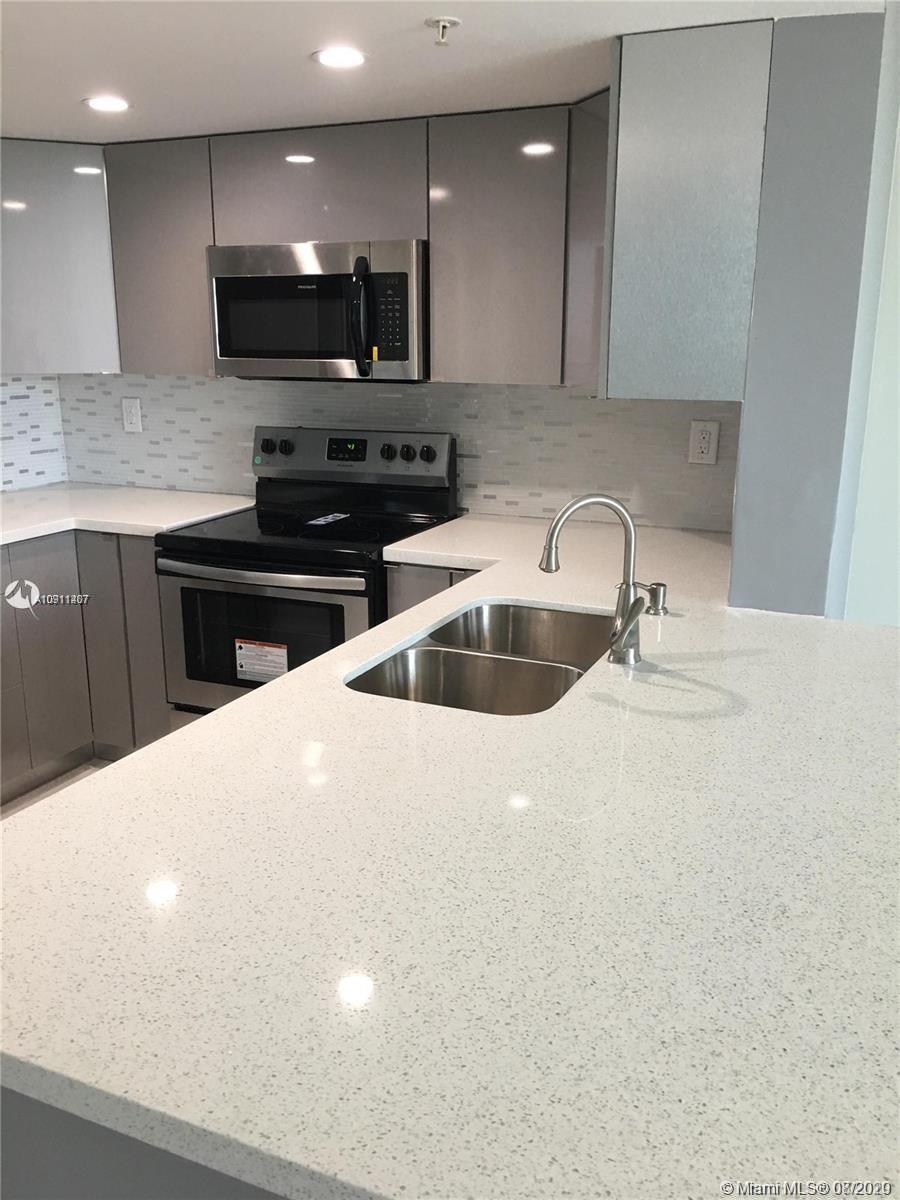 3000 Coral Way, Unit 1207 Miami, FL 33145 - Photo 6 of 8 a kitchen with stainless steel appliances a sink a stove a microwave a sink a refrigerator and a oven