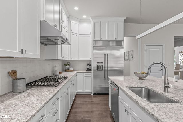a kitchen with stainless steel appliances granite countertop a sink a stove and cabinets