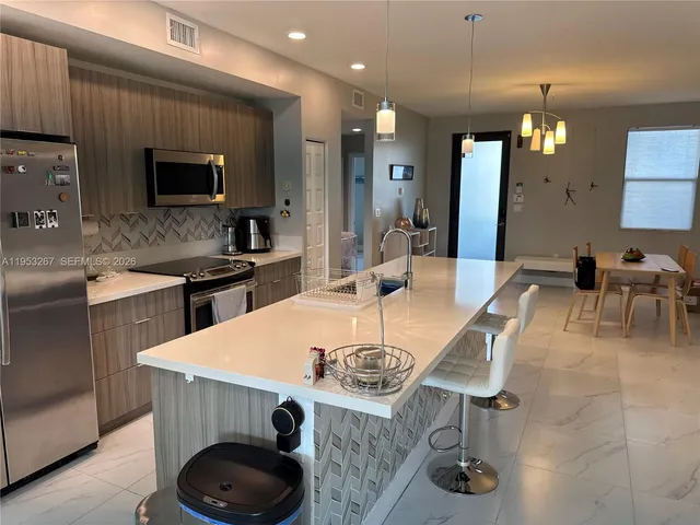 a large kitchen with a table and chairs