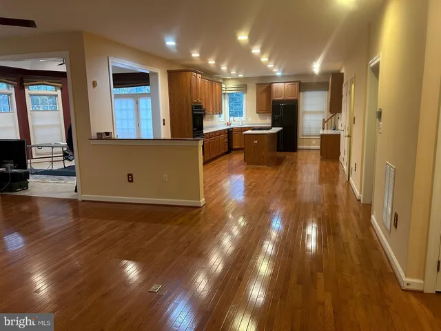 a view of a living room kitchen with hardwood floor and a large window