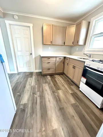a kitchen with wooden floors and appliances