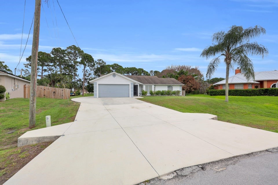 1950 Southwest Logwood Road Port St. Lucie, FL 34953 - Photo 2 of 32 a front view of a house with garden