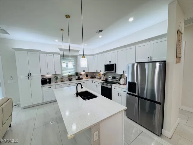 a kitchen with white cabinets and stainless steel appliances