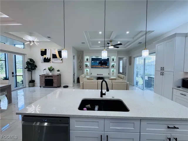 a kitchen with a sink a counter space appliances and cabinets
