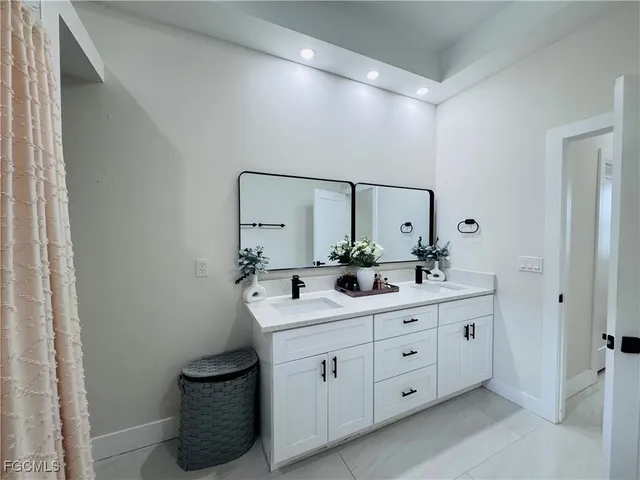 a spacious bathroom with a double vanity sink and mirror