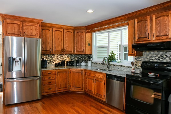 101 Sylvan Road Lancaster, MA 01523 - Photo 3 of 21 a kitchen with granite countertop stainless steel appliances a sink cabinets and a window