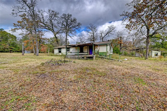 a view of house with a yard and outdoor seating