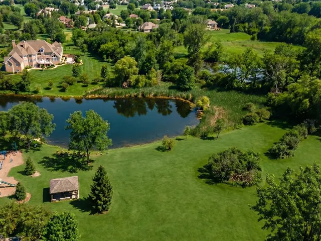 an aerial view of a house with a yard and lake view