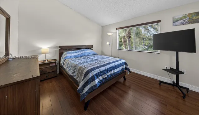 a bedroom with a bed tv and a window