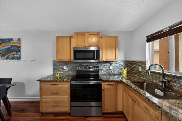 a kitchen with granite countertop a stove and a sink