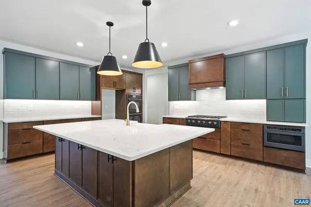 a kitchen with kitchen island a stove a sink a center island and wooden floor