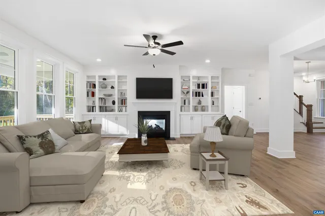 a view of a big room with wooden floor and windows