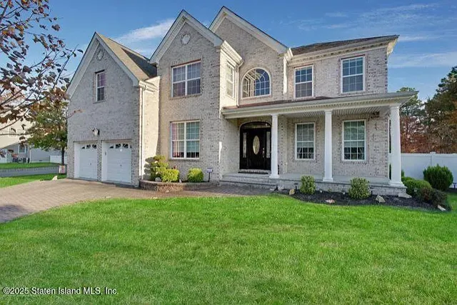a front view of a house with a garden and yard