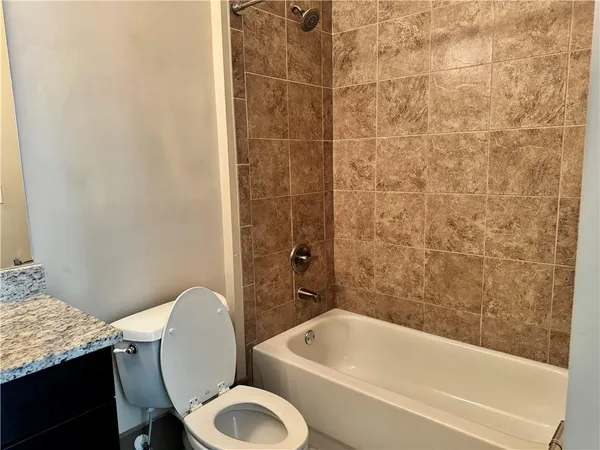 a bathroom with a granite countertop bathtub toilet and a sink