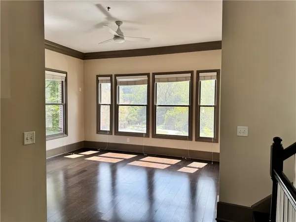 a view of an empty room with a window and wooden floor