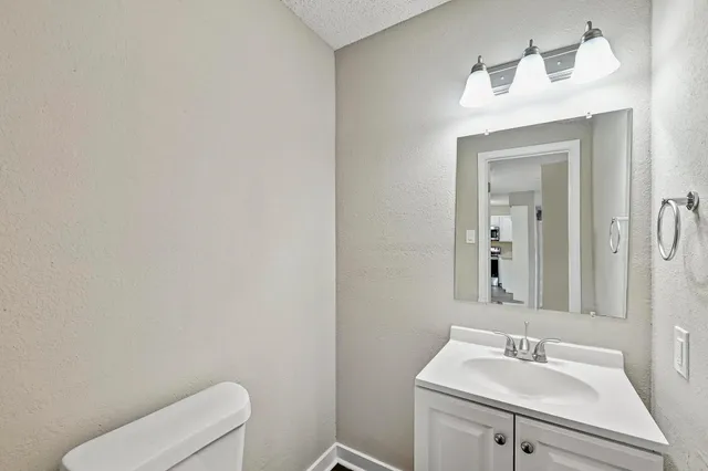a bathroom with a sink toilet and mirror