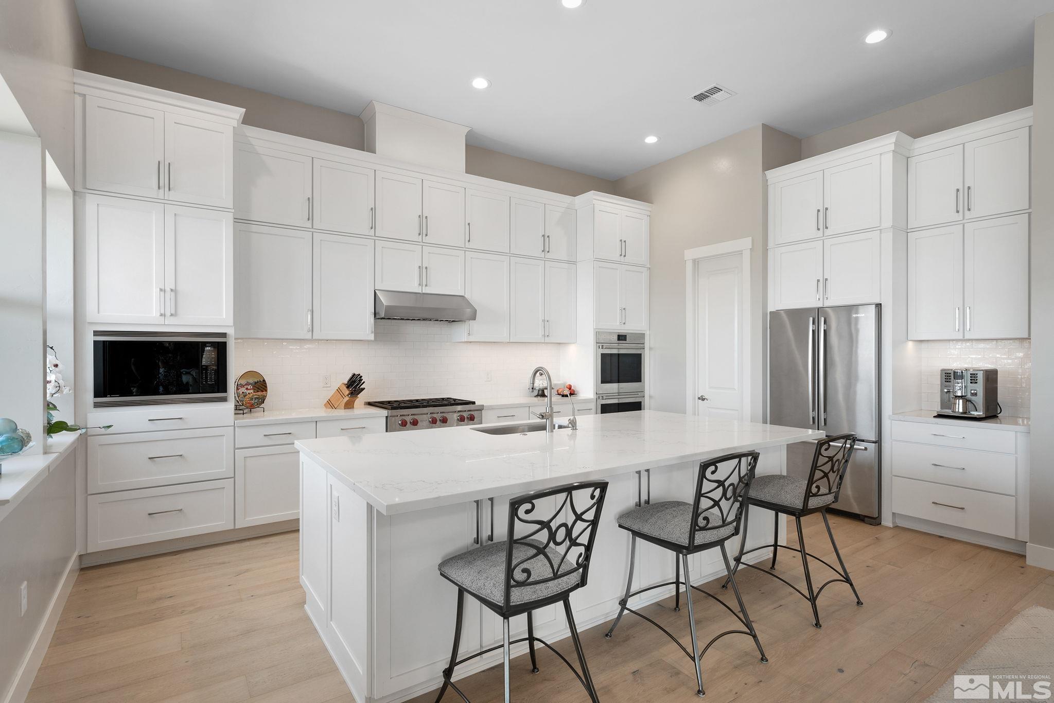 3011 Feathertop Drive Reno, NV 89521 - Photo 12 of 40 a kitchen with stainless steel appliances white cabinets a sink and a stove