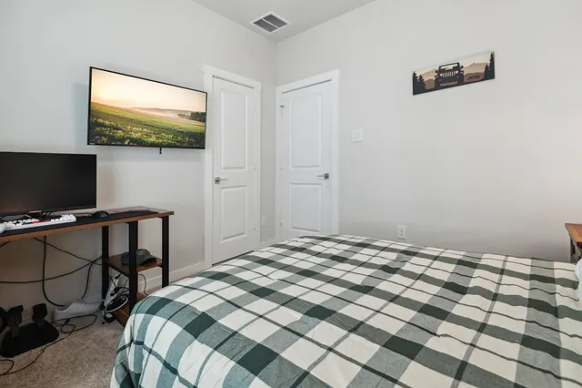 a bedroom with a bed and a flat screen tv