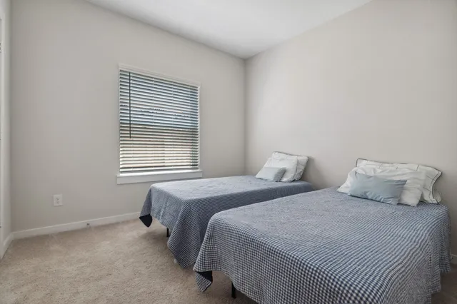 a bedroom with two beds and a window