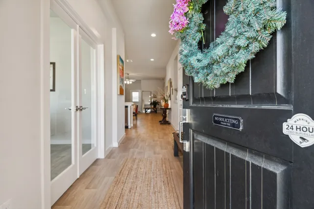 a hallway with a dining table & a chandelier