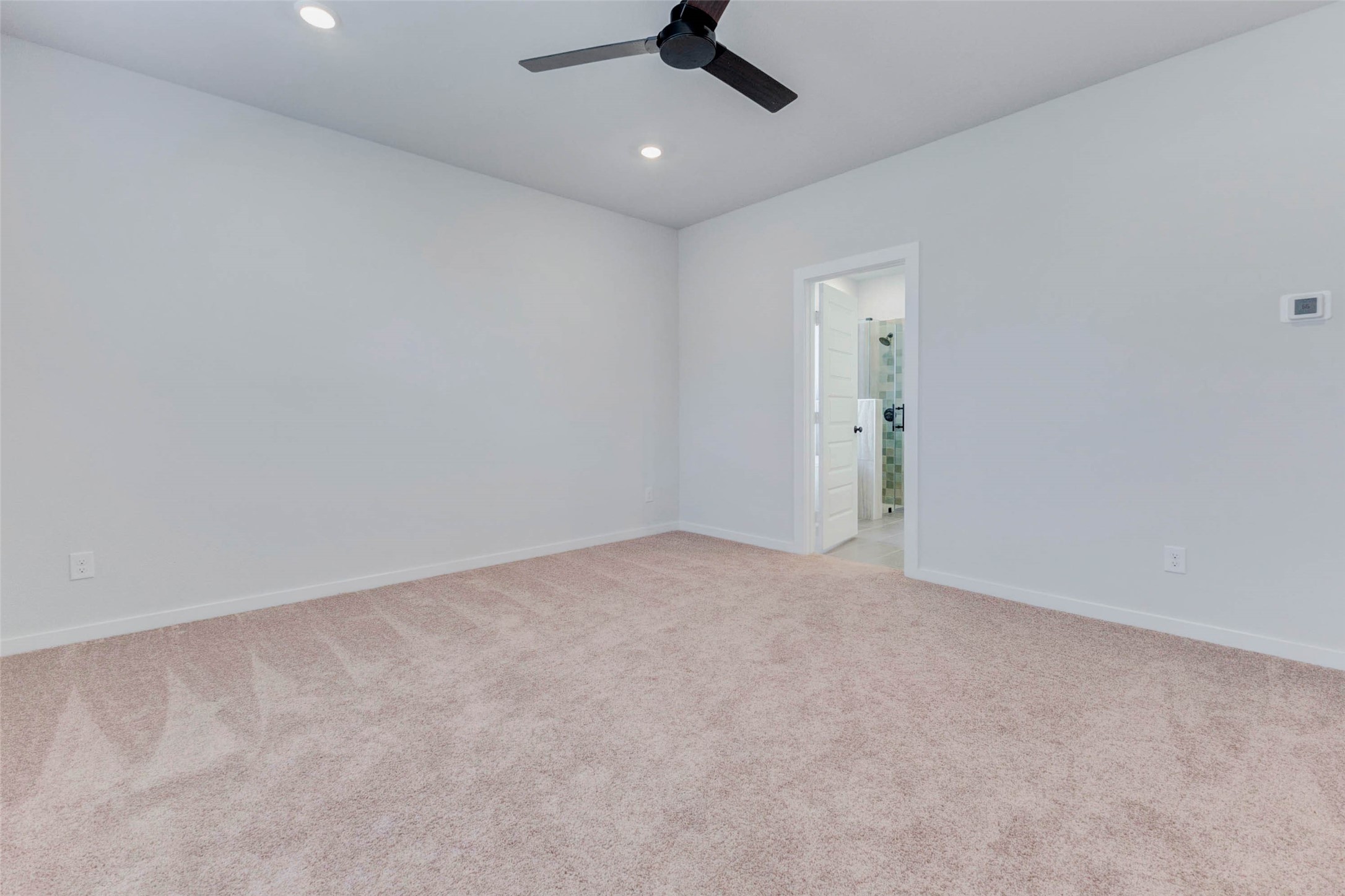 6406 Pomona Court Rosharon, TX 77583 - Photo 18 of 33 Retreat to the peaceful first-floor primary bedroom, where plush carpeting, recessed lighting, and a modern ceiling fan set the tone for rest and relaxation. Direct access to the ensuite bath makes this space the ultimate private getaway within your home.