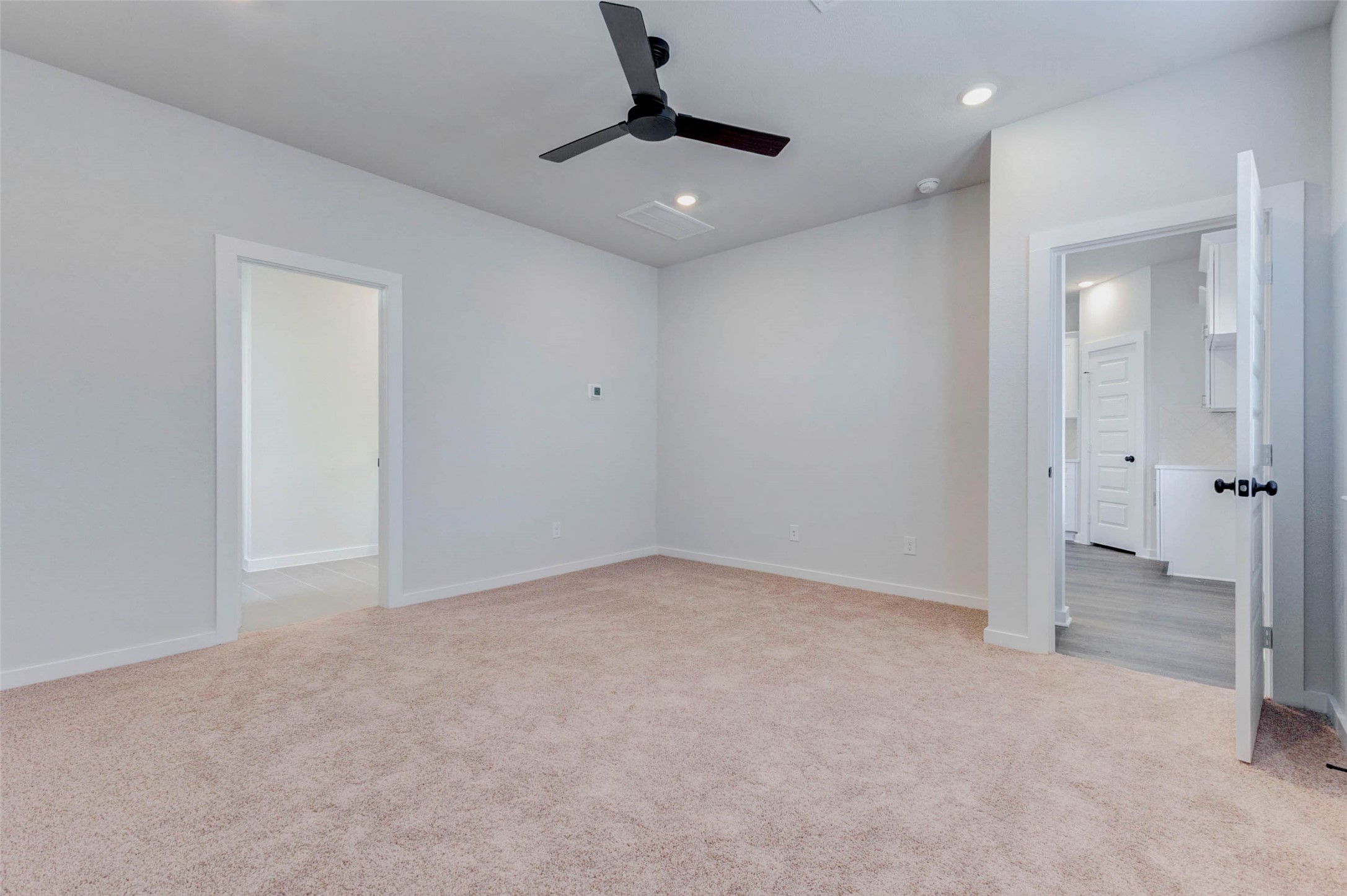 6406 Pomona Court Rosharon, TX 77583 - Photo 19 of 33 Another view of the spacious primary suite highlights easy access to the ensuite and main living area. Soft carpet underfoot and thoughtful lighting details elevate this serene and versatile retreat designed for comfort and convenience.