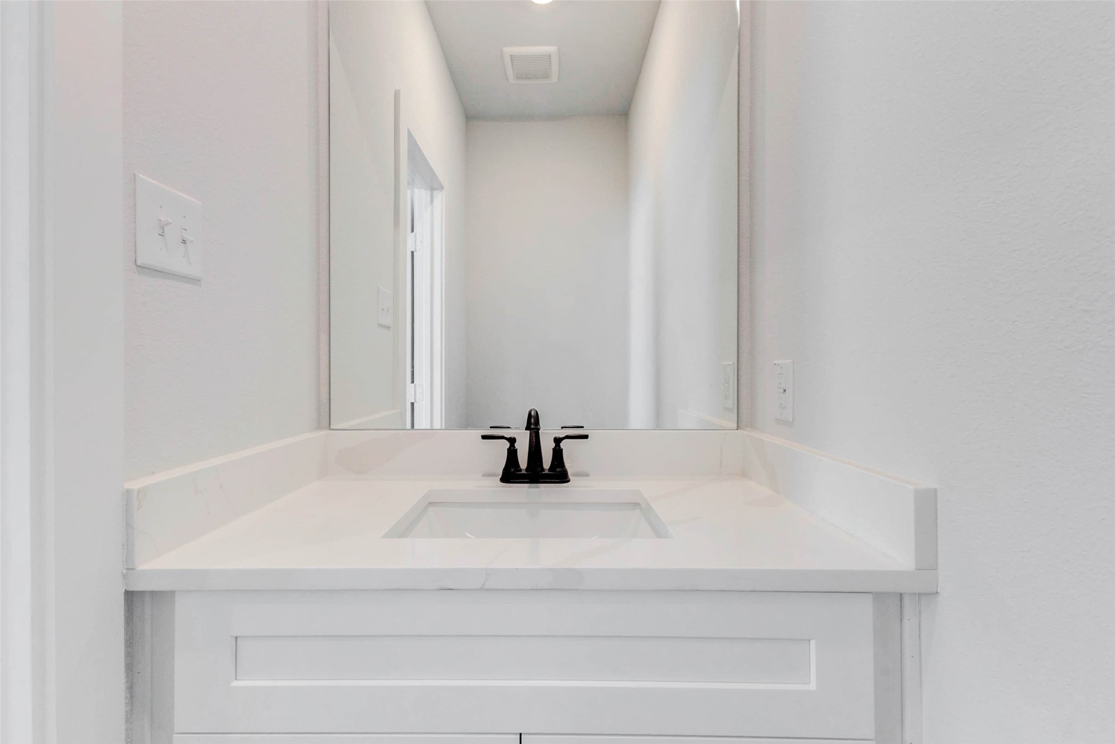6406 Pomona Court Rosharon, TX 77583 - Photo 23 of 33 This sleek powder bath is perfectly placed for guests and everyday use. Features include a single quartz vanity with a matte black faucet, soft-close cabinetry, and a generously sized mirror for a streamlined, elegant look.