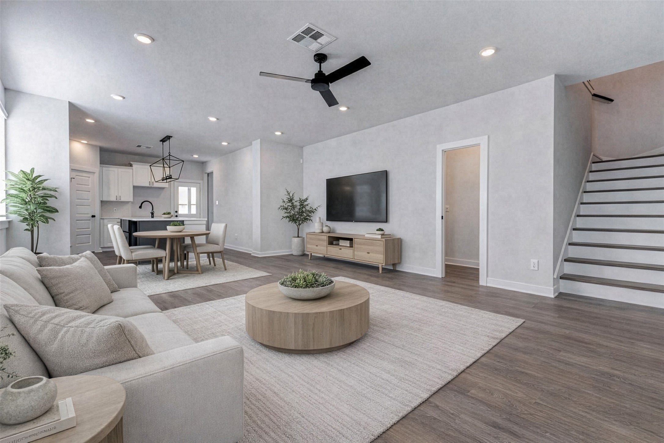 6406 Pomona Court Rosharon, TX 77583 - Photo 3 of 33 From this angle, you’ll appreciate the home’s main level flow where the kitchen, living, and stairwell connect with thoughtful functionality. Recessed lighting, fresh white walls, and warm-toned flooring give you a blank canvas ready for life and style. This photo has been virtually staged for visual reference.