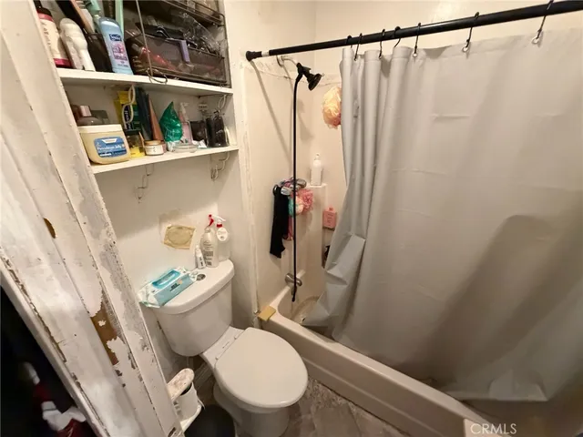 a white toilet sitting next to a shower curtain