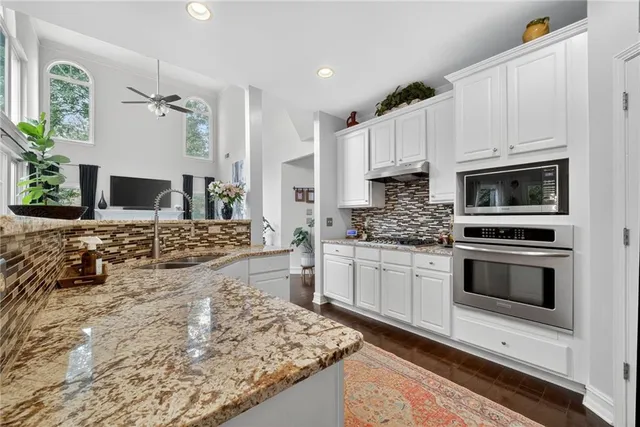 a kitchen with stainless steel appliances kitchen island granite countertop a stove a sink and a microwave