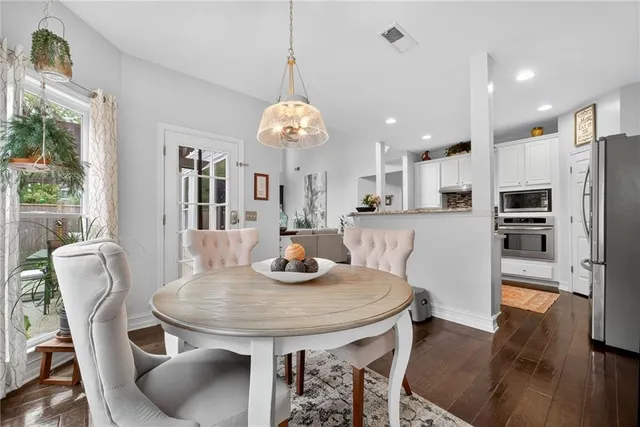 a view of a dining room and livingroom with furniture wooden floor a chandelier
