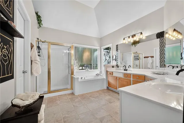 a large white kitchen with a refrigerator a stove a sink dishwasher and a dining table with wooden floor