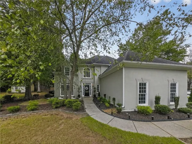 a front view of a house with yard and green space