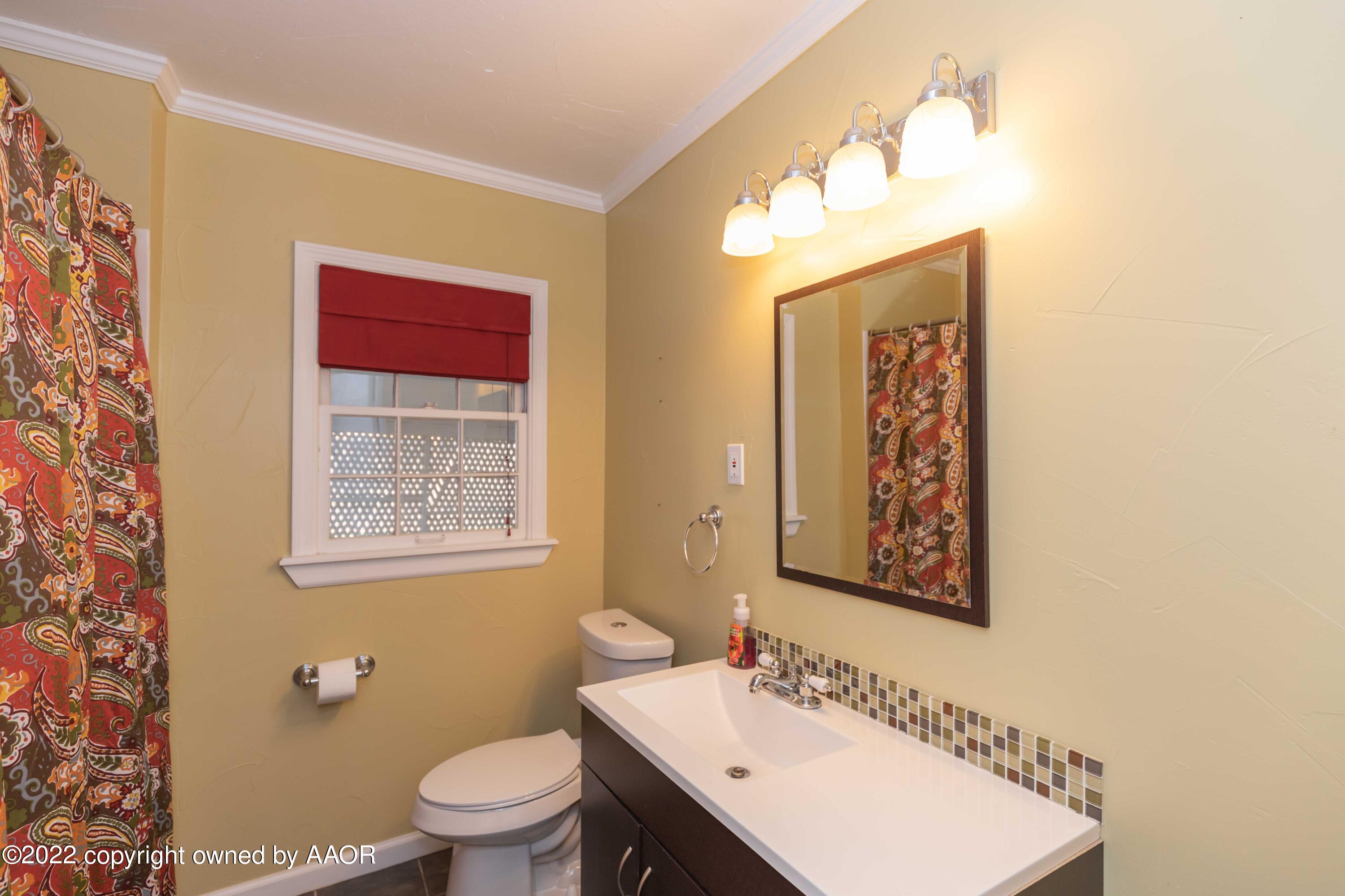 1006 South Lamar Street Amarillo, TX 79102 - Photo 11 of 32 a bath room with a toilet a sink and a mirror
