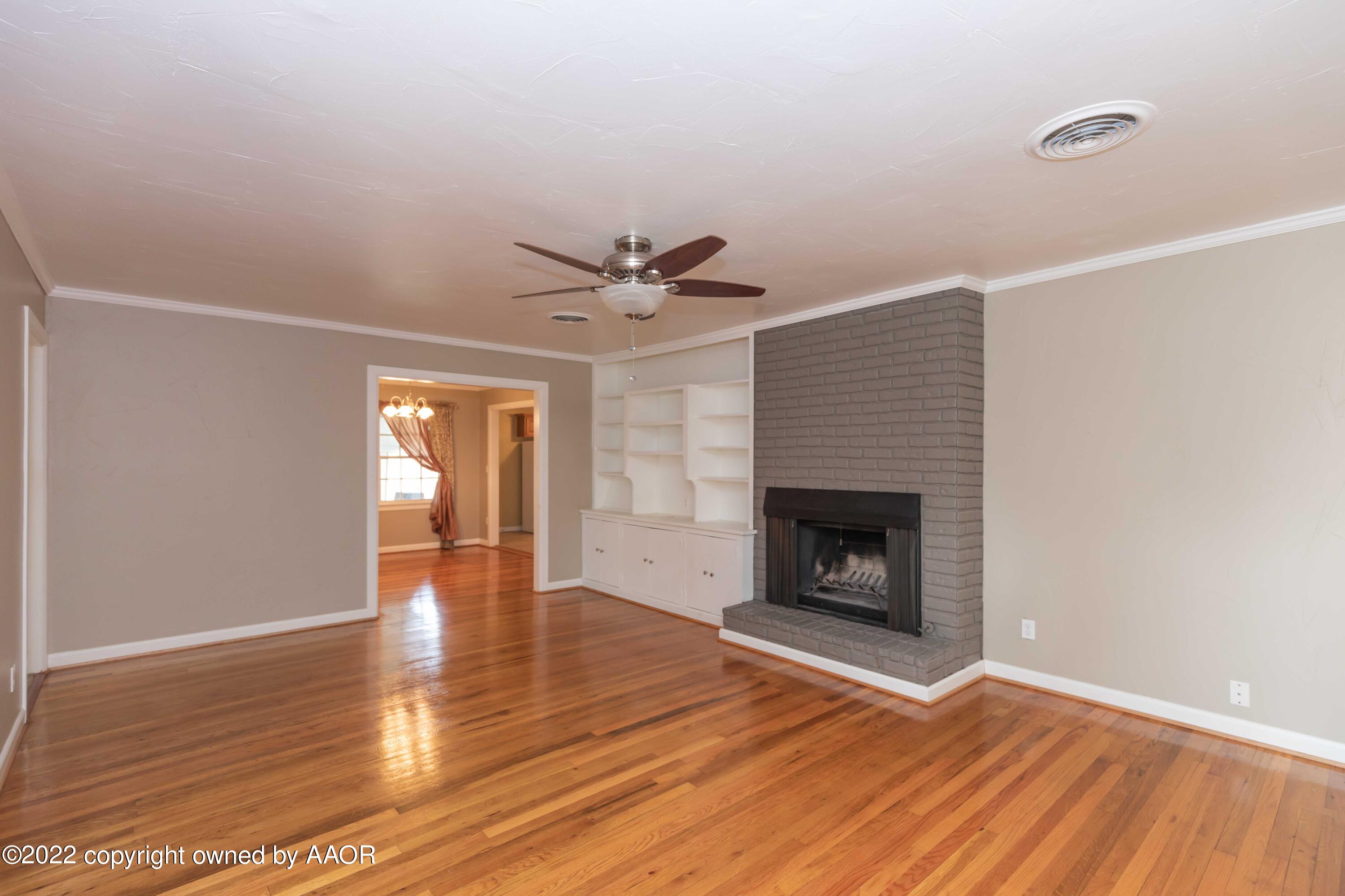 1006 South Lamar Street Amarillo, TX 79102 - Photo 4 of 32 a view of empty room with wooden floor and fireplace