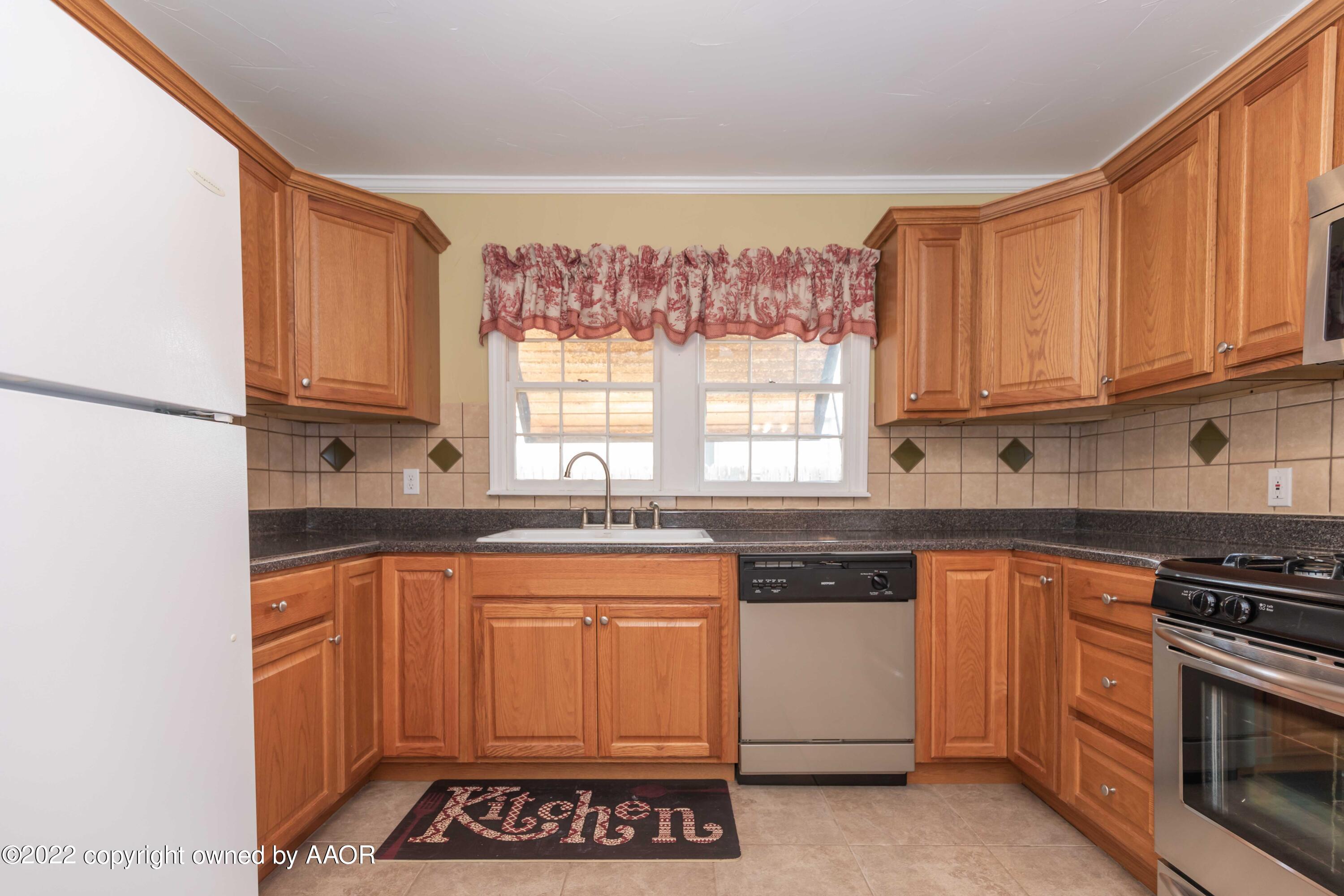 1006 South Lamar Street Amarillo, TX 79102 - Photo 7 of 32 a kitchen with stainless steel appliances granite countertop a stove a sink and a microwave