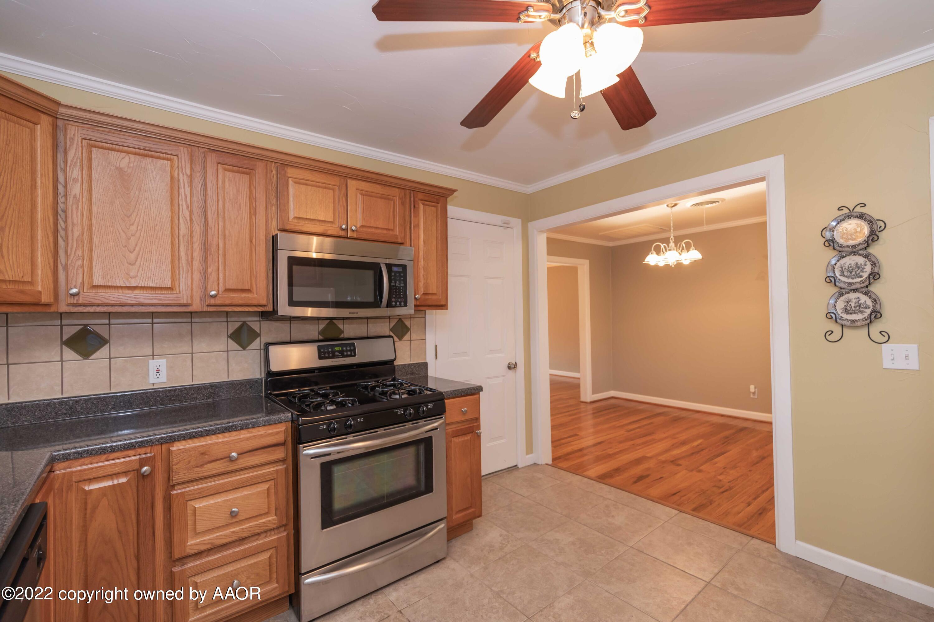 1006 South Lamar Street Amarillo, TX 79102 - Photo 8 of 32 a kitchen with stainless steel appliances granite countertop a stove and a microwave