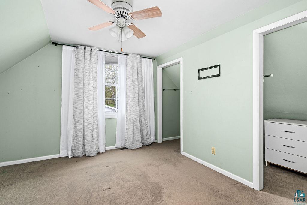 33 Nelson Drive Silver Bay, MN 55614 - Photo 20 of 40 Unfurnished bedroom with carpet, baseboards, vaulted ceiling, and a ceiling fan