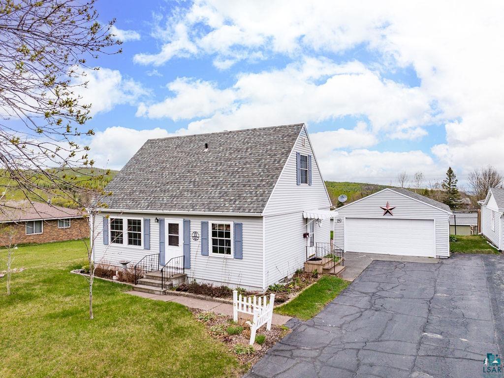 33 Nelson Drive Silver Bay, MN 55614 - Photo 2 of 40 Cape cod home with a garage, roof with shingles, a front lawn, and an outbuilding