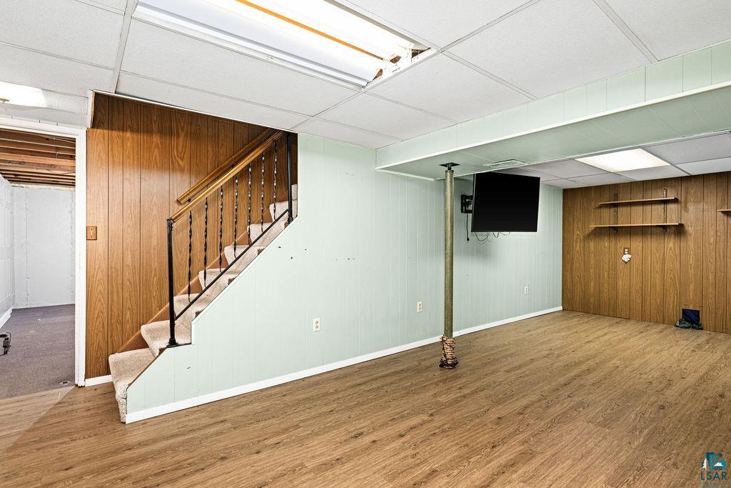 33 Nelson Drive Silver Bay, MN 55614 - Photo 26 of 40 Finished below grade area with wood finished floors, stairway, baseboards, wooden walls, and a paneled ceiling
