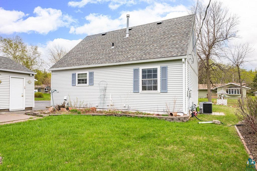 33 Nelson Drive Silver Bay, MN 55614 - Photo 6 of 40 Rear view of house with central AC, a shingled roof, and a yard