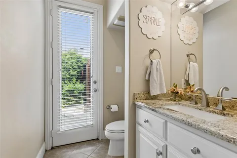 a bathroom with a granite countertop sink toilet and a mirror