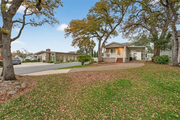 a front view of a house with a yard and trees