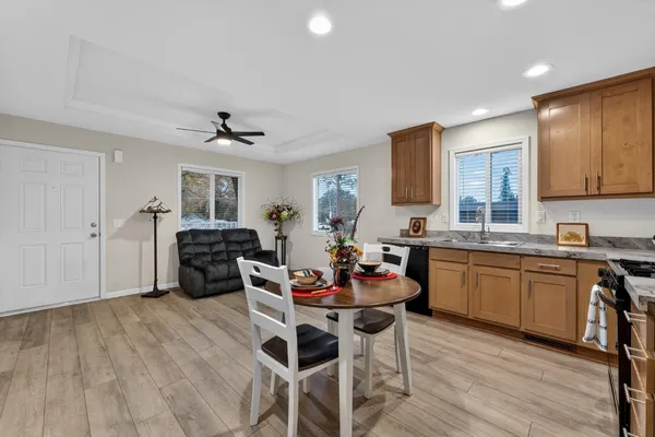a kitchen with stainless steel appliances kitchen island granite countertop a dining table chairs and granite counter tops