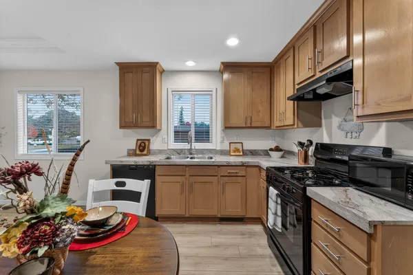 a kitchen with stainless steel appliances granite countertop a sink stove and cabinets