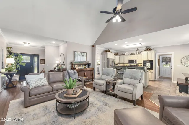 a living room with furniture a flat screen tv and a large window