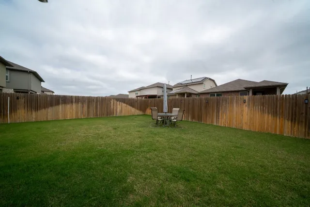 a view of a backyard with wooden fence
