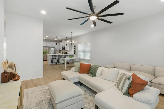 a living room with furniture and a view of kitchen