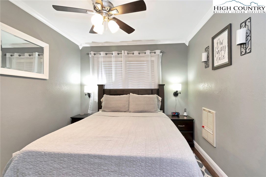 301 Pinnacle Inn Road, Unit 3230 Beech Mountain, NC 28604 - Photo 11 of 40 a bedroom with a large bed and a chandelier