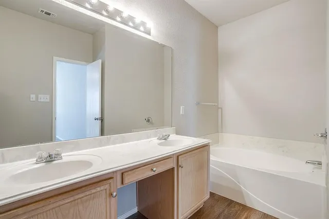 a bathroom with a sink a bathtub and a mirror